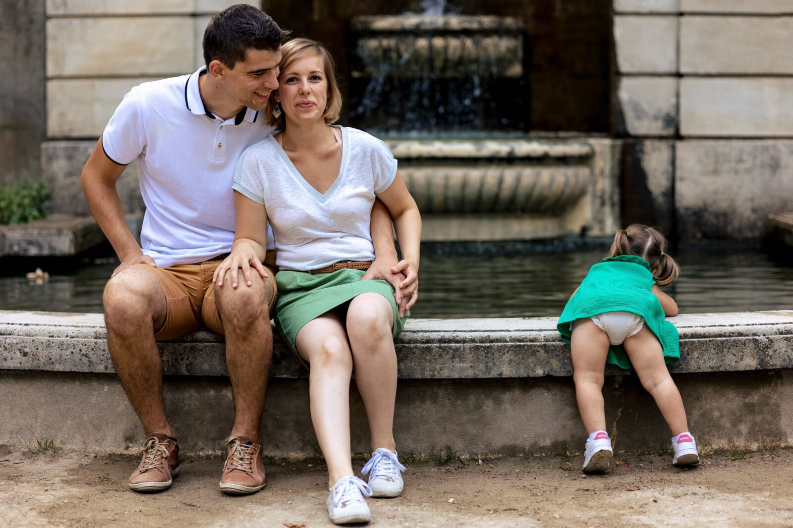 Une enfant qui se moque de l'appareil photo et prefere jouer dans l'eau lors d'une séance photo