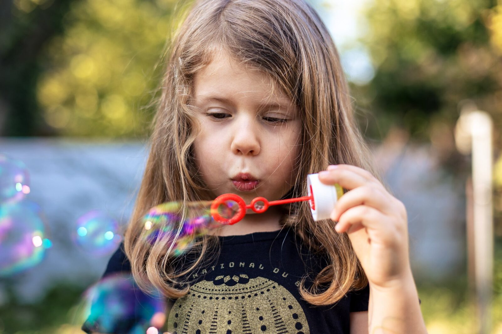 Jeune fille qui souffle des bulles en séance photo famille à la RObertsau